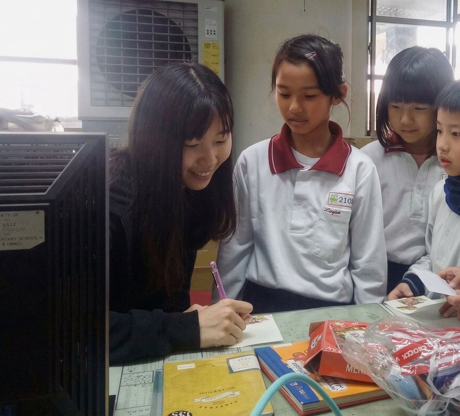 Shine Yin Teoh working with school children at a classroom table